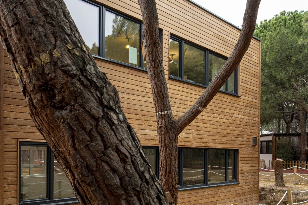 Centro educativo en Aravaca, Madrid, con fachada de madera.